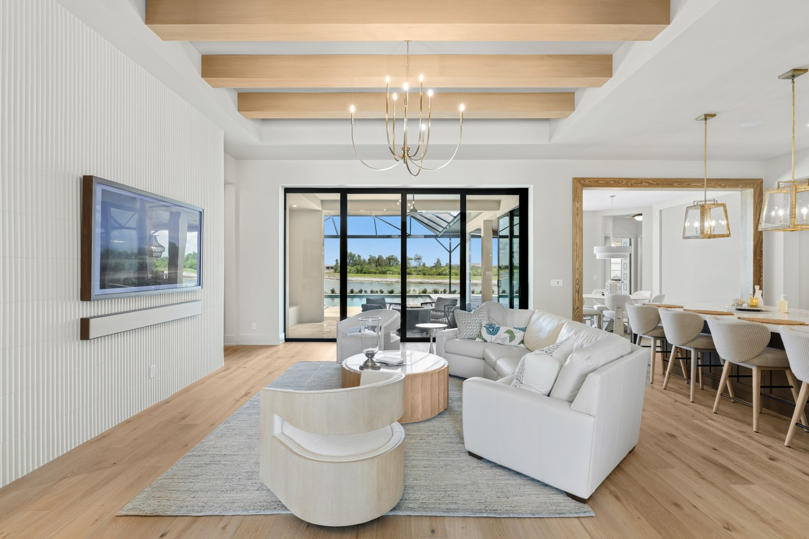 Light wood beams across a tray ceiling in an open living room
